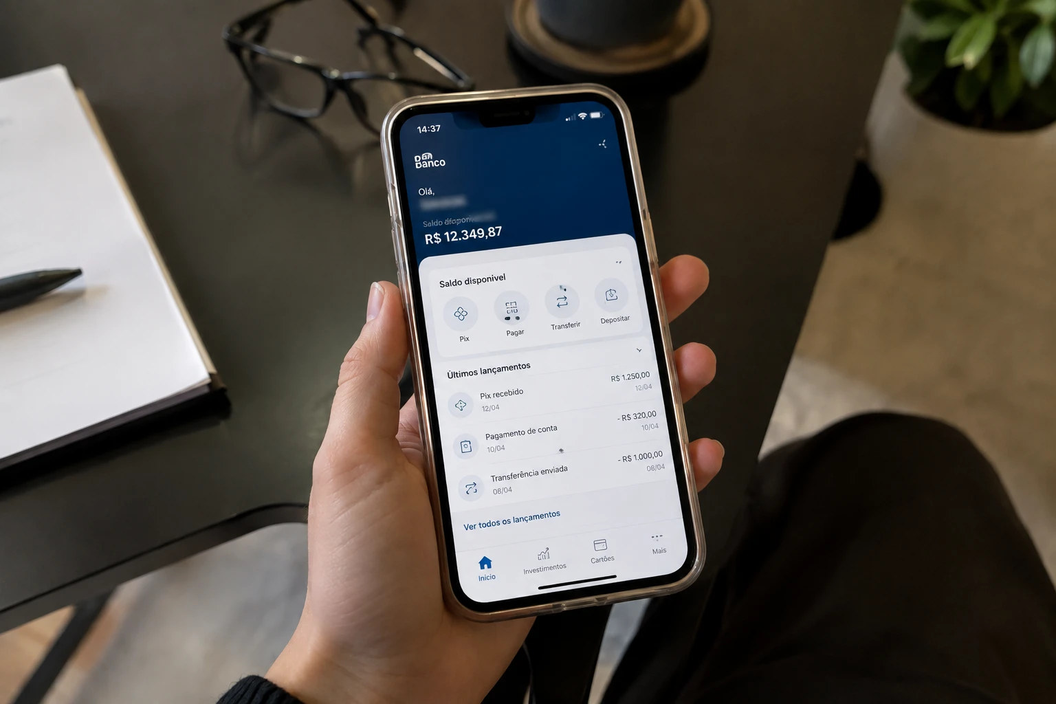 Celular com aplicativo bancário aberto, exibindo saldo e lançamentos